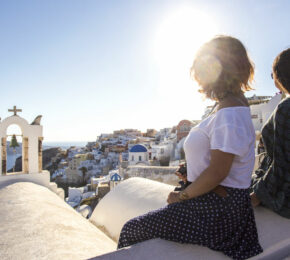 Two women sitting on a ledge overlooking the ocean, capturing moments of 2017.