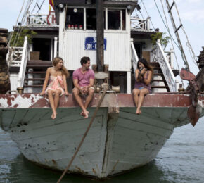 Three travelers on a boat in Vietnam.