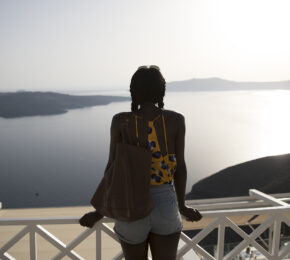 Girl-looking-onto-water-in-Santorini