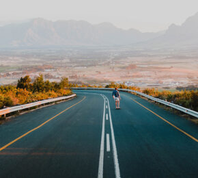 A person adventuring down an empty road with mountains in the background. #theweekendventure