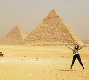 A woman is jumping in front of the UNESCO World Heritage Sites in Egypt.