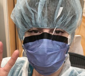 Incredible woman wearing a surgical mask making a peace sign.