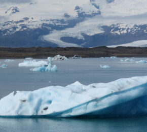 A group of icebergs floating in a body of water.