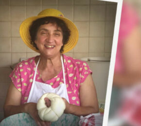 A woman in a hat holding a piece of bread on a farm.