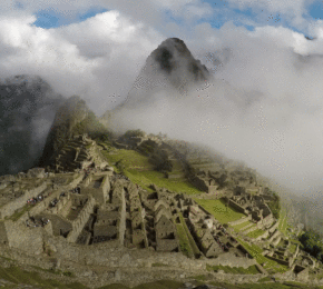 The ruins of Machu Picchu are surrounded by clouds.