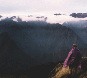 A person hiking the Inca Trail to reach the top of a mountain.