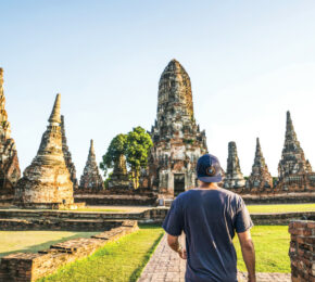 A man walking through a temple in Thailand.