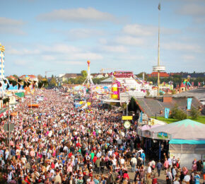 A crowd of people at an amusement park during Oktoberfest.