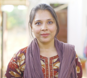 A woman standing in front of a rack of clothes at Dhonk crafts centre.