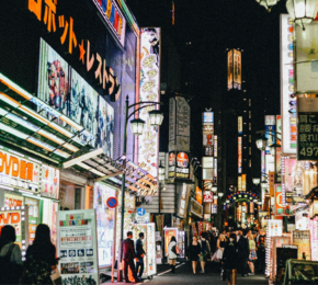 People walking down a street in tokyo at night.