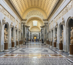 A hallway full of statues in a museum.