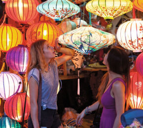 Two women experiencing Vietnam's colorful lantern market.