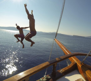 adventure travel - image of two boys jumping from a boat