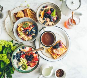 Vegan breakfast with waffles and fruit on a marble table.