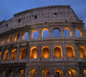         The colosseum is lit up at night.