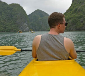 Dom Oliver is paddling a yellow kayak on a body of water.