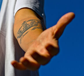 A person with a travel tattoo on his arm.