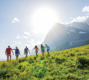 A group of active people walking in a field.