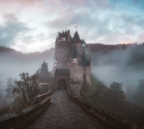 A haunted castle sits on top of a hill in the fog, making it one of the most haunted places in the world.