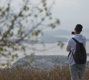 A first-time backpacker standing on top of a hill.