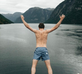 A man jumping off a cliff into a body of water during a trip to Scandinavia.