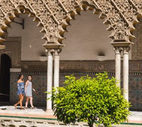 Two women walking in front of an ornate building used as a filming location for Game of Thrones.