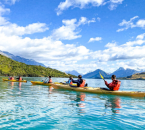 A group of people paddling in kayaks on a lake.