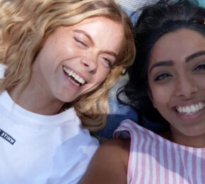 Two women keeping their mental health in check while enjoying a beach day during Covid-19.