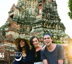 A group of people are posing in front of one of the most beautiful destinations in Thailand, a temple.