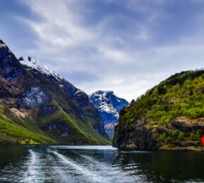 view of fjords in Norway from boat with Norwegian flag