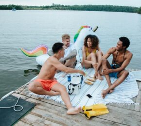 friends laughing on deck on holidays: Pexel: Ron Lach