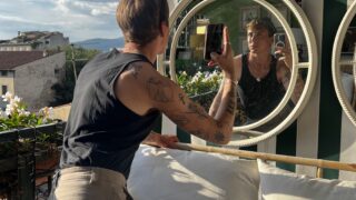 Young man with tattoos looking in the mirror