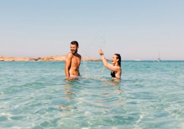 Image of a man and woman in the sea, playfully splashing about