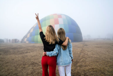 Two LGBTQ women enjoying a hot air balloon adventure.