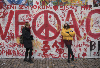 Political graffiti in red on a white exterior wall