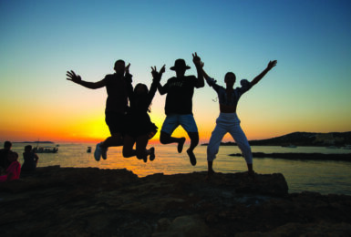 A group of people jumping in the air on Ibiza.