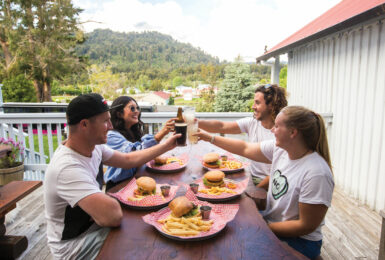 A group of people toasting at a table with plates of food during Mardi Gras.