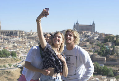 A group of people taking a selfie in front of a city during travel to Spain.