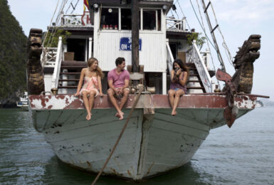 Three travelers on a boat in Vietnam.