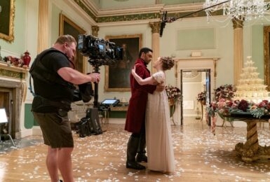A man and woman are kissing in a large room at Bridgerton filming locations.