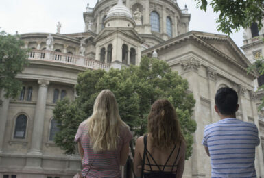 A group of people standing in front of an ornate building in Budapest.