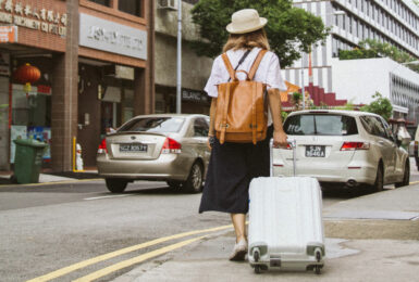 Girl walking down street with suitcase