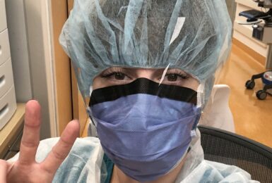 Incredible woman wearing a surgical mask making a peace sign.