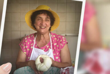 A woman in a hat holding a piece of bread on a farm.