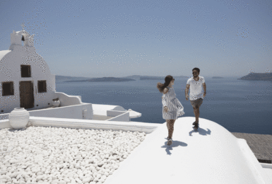 A couple enjoying a romantic escape on the roof of a white building.