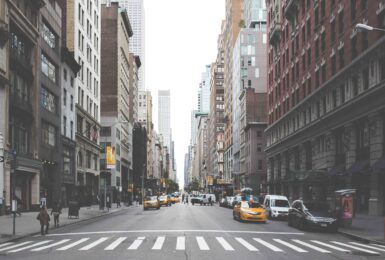 A bustling city street in Soho, New York, lined with towering buildings ideal for shopping enthusiasts.