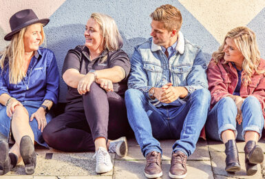 A group of contiki trip managers sitting in front of a wall.