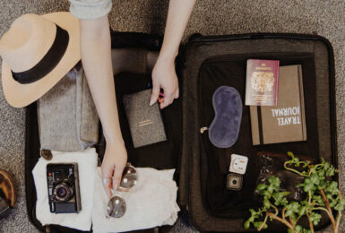 A woman is unpacking her travel essentials from a suitcase during her summer vacation in Europe.