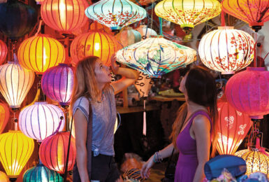 Two women experiencing Vietnam's colorful lantern market.