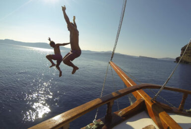 adventure travel - image of two boys jumping from a boat